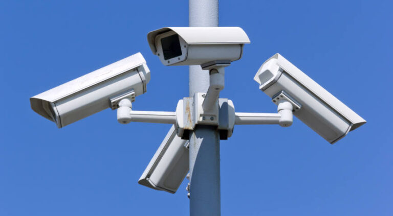 Four security cameras on blue sky